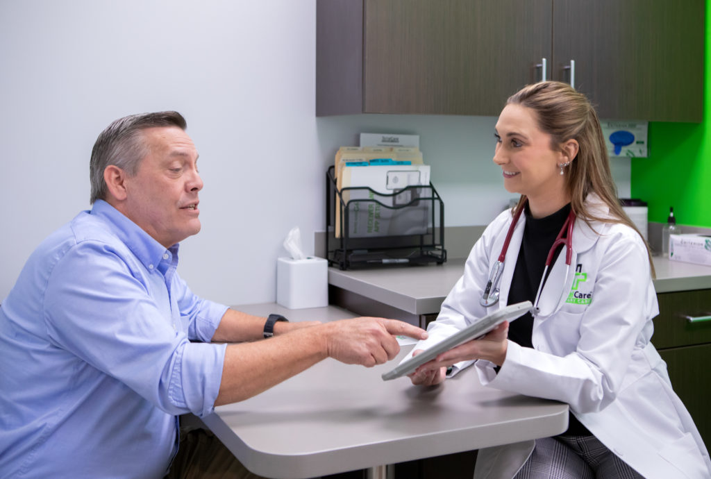 A patient and a Total Health Primary Care provider review results together at a clinic table.